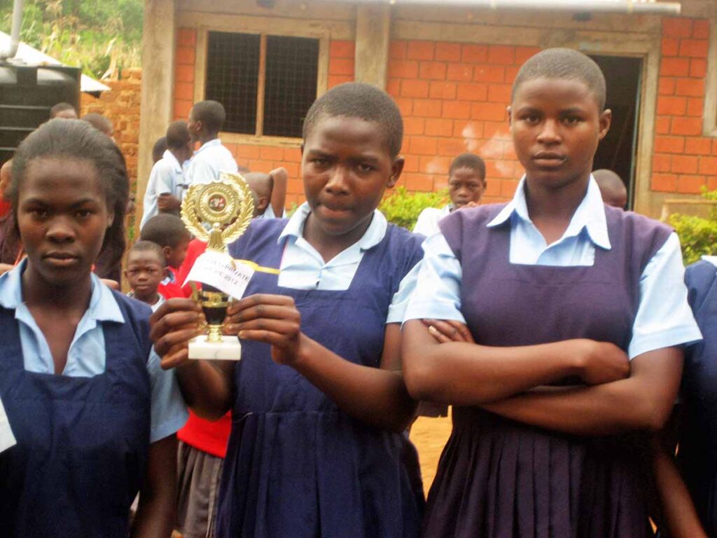 Kenyan students holding the award they got for most improved school in the county of Kiisi